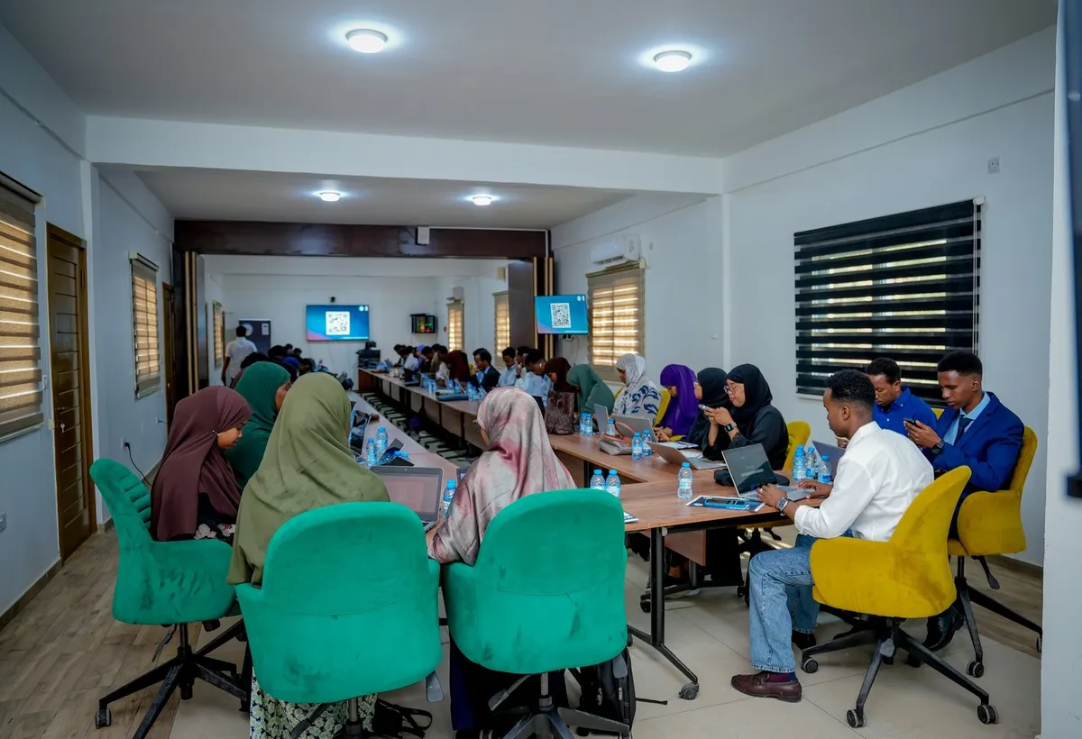Participants working on laptops around a conference table during a training session